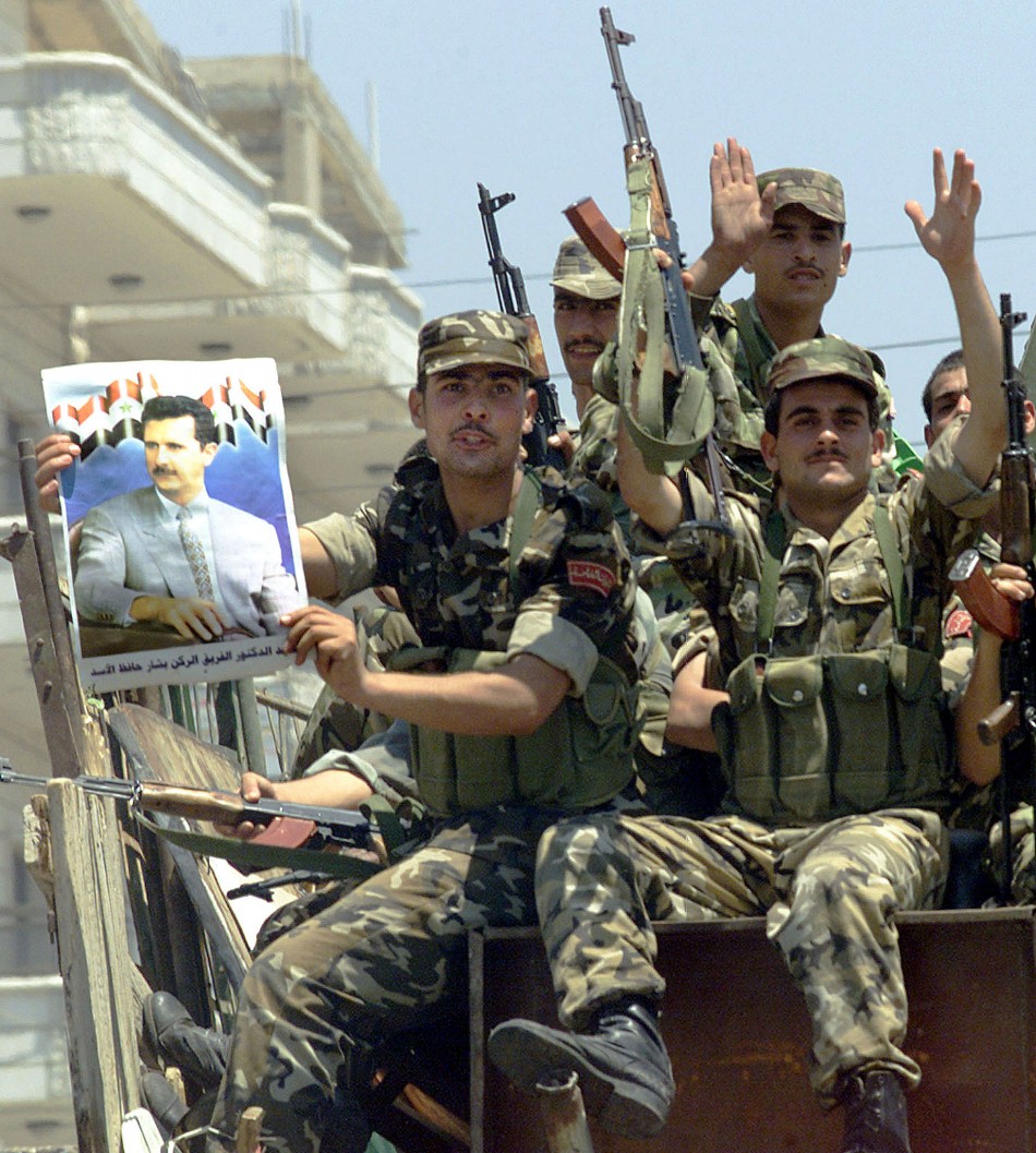 syrian-soldier-displays-poster-president-bashar-al-assad