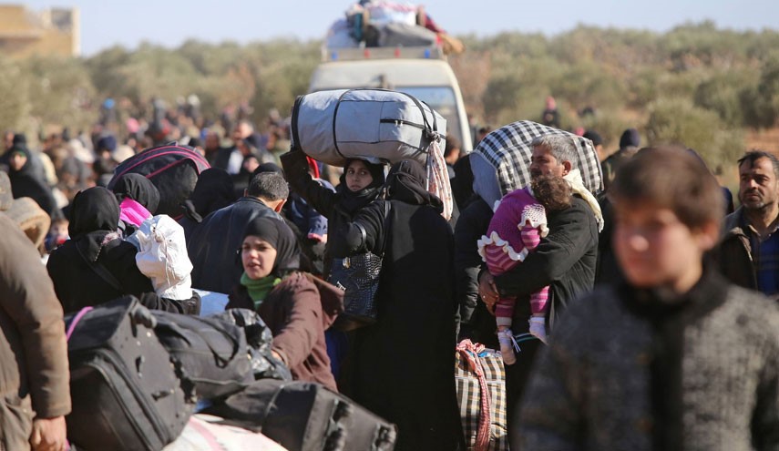 Syrian residents fleeing the violence gather at a checkpoint, manned by pro-government forces, in the village of Aziza on the southwestern outskirts of the northern Syrian city of Aleppo on December 8, 2016. Syria's army battled to take more ground from rebels in Aleppo after President Bashar al-Assad said victory for his troops in the city would be a turning point in the war. / AFP PHOTO