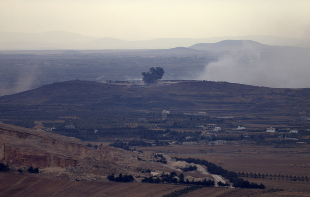 A picture taken from the hill village of Buqaata in the Israeli-annexed Syrian Golan Heights shows smoke ascending from alleged shelling by Syrian government forces on Islamic State group's positions near the Syrian village of Jubata al-Khashab on October 6, 2015. AFP PHOTO / JALAA MAREY