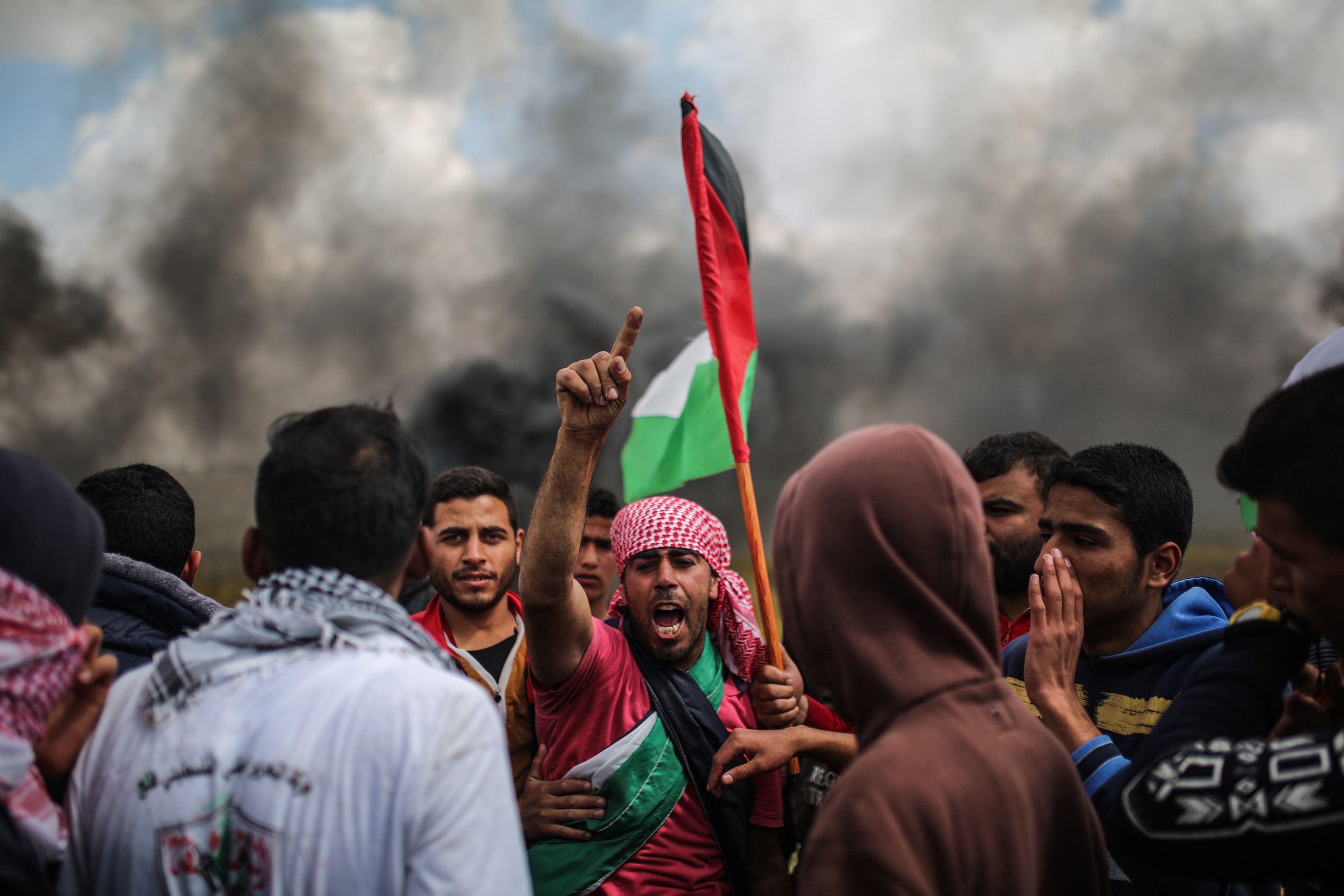 KHAN YUNIS, GAZA - MARCH 30: Demonstrators shout slogans and hold Palestinian flags during the demonstration under the name of the "Great Return March" at Israeli border in eastern part of Khan Yunis, Gaza on March 30, 2018. Dubbed the Great Return March, Fridays rallies in the Gaza Strip also coincide with Land Day, which commemorates the murder of six Palestinians by Israeli forces in 1976. It is also intended to pressure Israel to lift its decade-long blockade of the coastal enclave. (Photo by Mustafa Hassona/Anadolu Agency/Getty Images)